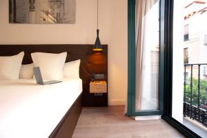 a bedroom with a bed and a window at Woohoo Rooms Fuencarral in Madrid