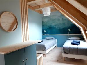 Habitación con 2 camas y espejo. en Les Burons du Mont-Dore, en Le Mont-Dore