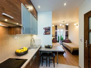 a kitchen with a sink and a bowl of fruit on a counter at Vanilla Apartment 2 in Krakow