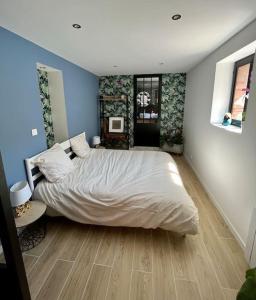 紹萊的住宿－La bâtisse de Manel，卧室配有白色大床和蓝色的墙壁
