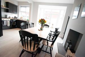 una mesa de comedor con un jarrón de flores. en Ideal Lodgings in Royton en Royton