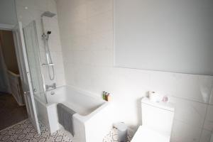 a white bathroom with a shower and a toilet at Ideal Lodgings in Royton in Royton +28 photos