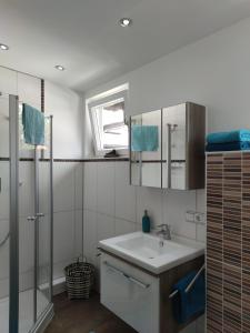 ein Bad mit einem Waschbecken und einer Dusche in der Unterkunft Ferienwohnung Haus Alpenrebe in Schönau am Königssee