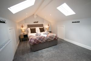 a bedroom with a bed in a attic with skylights at Ideal Lodgings in Royton in Royton