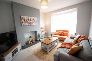 sala de estar con sofá y mesa en Ideal Lodgings in Royton en Royton