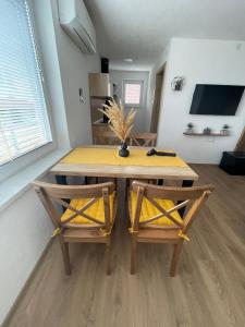 a dining room table with two chairs and a yellow table at Apartments and rooms pri Bašlju in Cerkno
