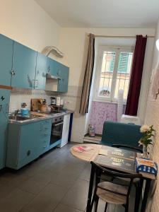 a kitchen with blue cabinets and a table and a dining room at Violet 27 in Florence