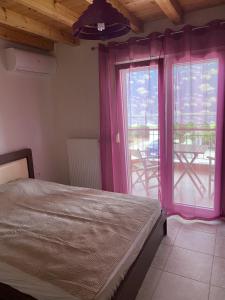 a bedroom with a bed and a window with a patio at Kalives Sithonia Family house in Kalyves Poligirou