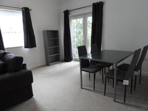 a dining room with a black table and chairs at Beautiful 2-Bed Apartment in Poulton-le-Fylde in Poulton le Fylde