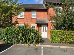 a house with a plant in front of it at Beautiful 2-Bed Apartment in Poulton-le-Fylde in Poulton le Fylde