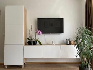 un centro de entretenimiento blanco con TV en la pared en Nice to stay, en Visaginas