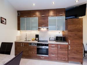 cocina con armarios de madera y microondas en Vanilla Apartment 1, en Cracovia