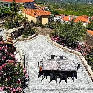 una mesa y sillas en un patio con flores en CASA LAURALINO vallée du Douro en Sanfins do Douro