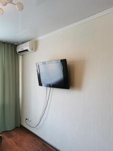 uma televisão pendurada numa parede num quarto em 1 комн квартира в центре em Qostanay
