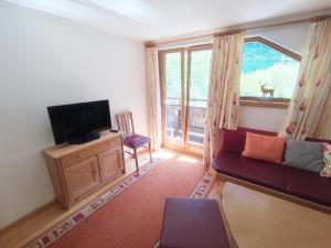 a living room with a couch and a television at Pretty Holiday Home in Mayerhofen with Balcony in Mayrhofen