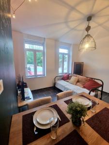 a living room with a table and a couch at La Trappiste in Liévin