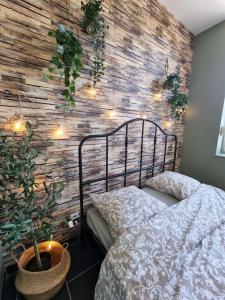 una camera da letto con un muro di mattoni, un letto e luci di La Trappiste a Liévin