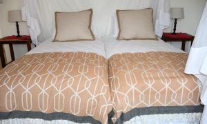 łóżko z dwoma poduszkami na górze w obiekcie Cheetah View Lodge w mieście Otjiwarongo