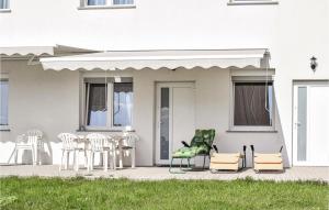 a patio with chairs and a table and a house at Nice Apartment In Sarbinowo With Kitchen in Sarbinowo