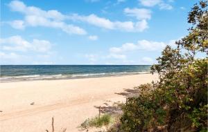 a sandy beach with the ocean in the background at Nice Apartment In Sarbinowo With Kitchen in Sarbinowo