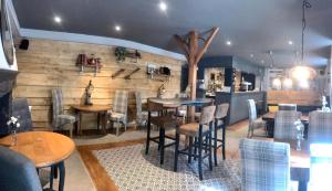 a restaurant with tables and chairs in a room at Le Relais D'Aulnay in Aulnay