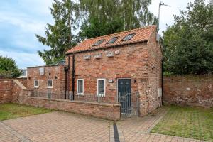 an old brick building with a black door and a fence at The Smithy in York +12 photos