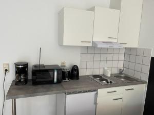 a small kitchen with a microwave and a sink at Ap. Stern in Marburg an der Lahn