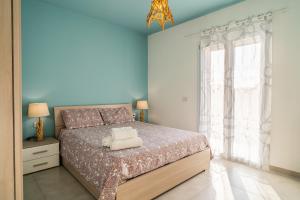 een slaapkamer met een bed en een groot raam bij Pilar Apartment Vista Mare in Portopalo
