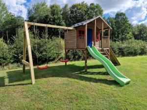 a playground with a house and a slide at Mana Village - Jacuzzi & Sauna in Barłomino