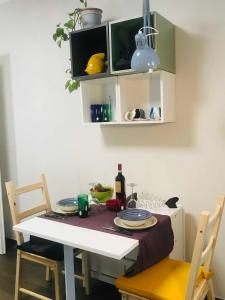 een eettafel met 2 stoelen en een tafel met borden bij Donna Flor casa vacanze in Barletta