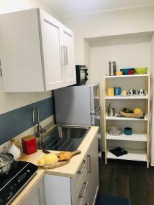 a kitchen with white cabinets and a sink at Donna Flor casa vacanze in Barletta