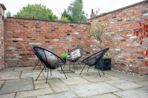 three black chairs sitting in front of a brick wall at The Smithy in York