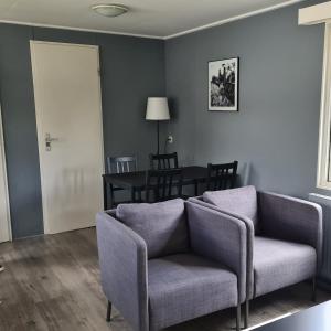a living room with a couch and a table at Holiday Chalet Basic in Hensbroek