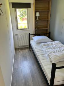 mały pokój z 2 łóżkami i oknem w obiekcie Holiday Chalet Basic w mieście Hensbroek