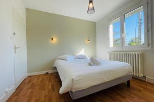1 dormitorio con 1 cama con sábanas blancas y ventana en La Marnière - Magnificent house with garden in Chambray-lès-Tours, en Chambray-lès-Tours