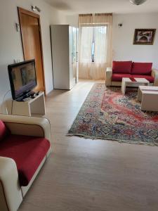 a living room with a red couch and a tv at Vila Zvizdic- apartman in Ilijaš