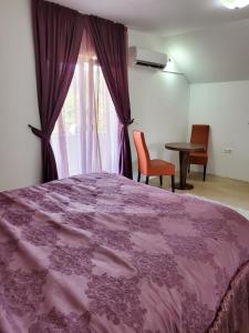 1 dormitorio con cama rosa y ventana en Vila Zvizdic en Ilijaš