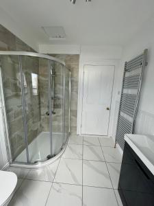 a white bathroom with a shower and a sink at 57 Main Street Newcastle Luxury Central Apartment in Newcastle