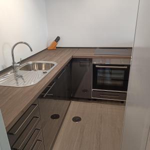 a kitchen with a sink and a microwave at Duquesa Harbour Club Aparthotel in Manilva