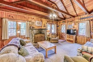 a living room with a couch and a tv and a fireplace at Alpine Cottage in Shaver Lake