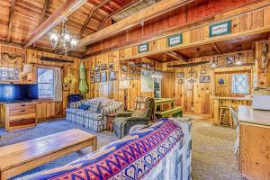 a living room with a couch and a tv in a cabin at Alpine Cottage in Shaver Lake