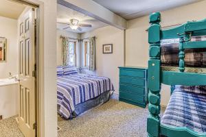 a bedroom with a bunk bed and a bathroom at Alpine Cottage in Shaver Lake