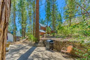a barbecue in a stone wall in a forest at Alpine Cottage in Shaver Lake