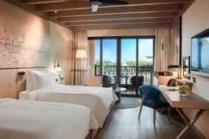 a hotel room with two beds and a balcony at Saadiyat Rotana Resort and Villas in Abu Dhabi