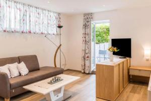 a living room with a couch and a tv at Appartement-Amber in Überlingen