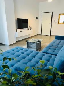 un gran sofá azul en una habitación con mesa en Solen Apartments en Durrës