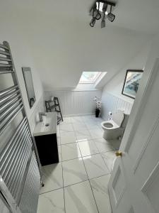 a white bathroom with a toilet and a sink at 57 Main Street Newcastle Luxury Central Apartment in Newcastle