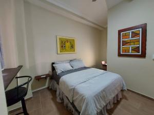 a bedroom with a bed and a chair in it at Casa Kamanda, Zona Colonial, Santo Domingo in Santo Domingo