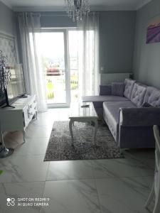 een woonkamer met een bank en een tafel bij Apartament Lawendowy in Kudowa-Zdrój