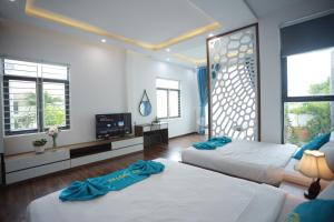 a bedroom with two beds and a tv in it at CT HomeStay Da Nang in Danang